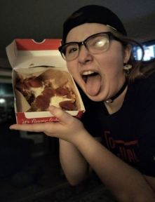 Lilly Lewis proudly(?) displaying the pizza she's going to consume before having the most violent liquidy foamy diarrhea known to man (she's lactose intolerant.)